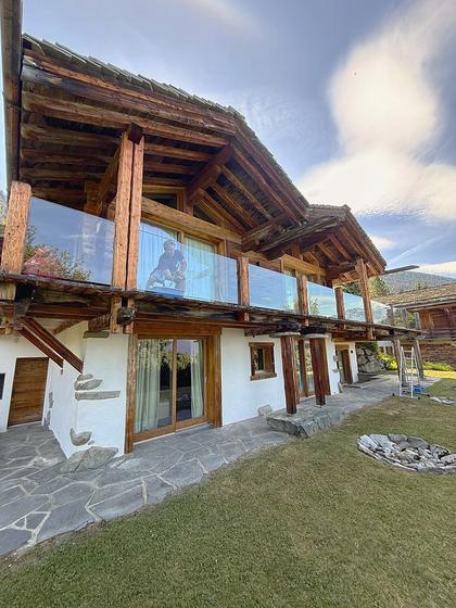 A chalet exterior with clean glass balustrades and windows.