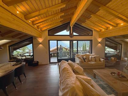 A finished chalet living room with clean glazing and mountain views.