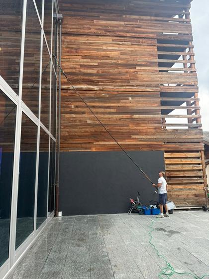 Water-fed pole cleaning a full-height glazed elevation.